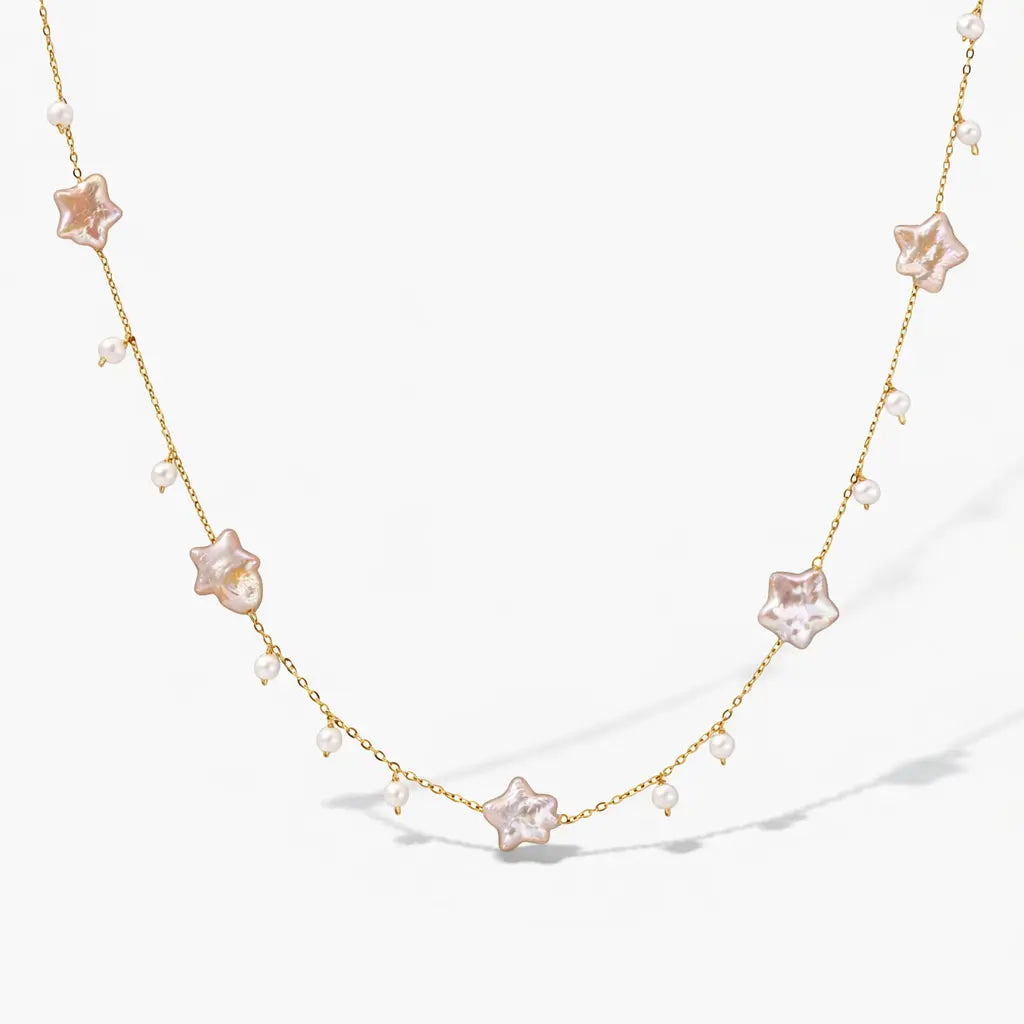 Gold vermeil necklace with star-shaped pearls and small round pearls on a white background
