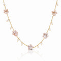 A delicate gold chain necklace featuring five pale pink star-shaped charms and small white pearl beads, displayed on a clean white background with a soft reflection.