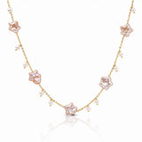 A delicate gold chain necklace featuring five pale pink star-shaped charms and small white pearl beads, displayed on a clean white background with a soft reflection.