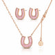 Rose gold jewelry set featuring a horseshoe-shaped pendant necklace, matching stud earrings, and a small clover charm on a delicate chain, displayed on a clean white background.