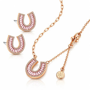Rose gold jewelry set featuring a horseshoe-shaped pendant necklace, matching stud earrings, and a small clover charm on a white background.