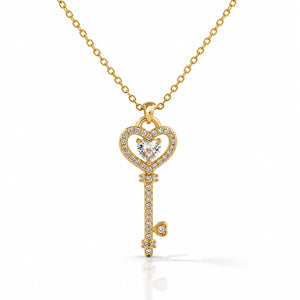 Gold key-shaped pendant necklace with diamonds on a white background
