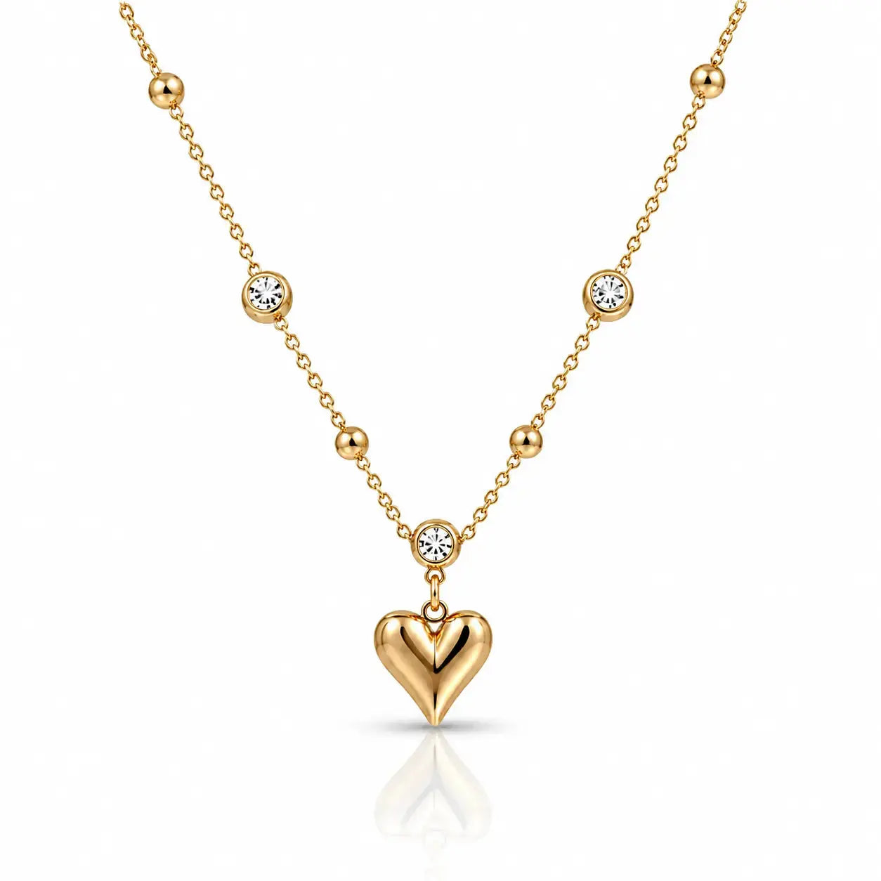 A gold necklace featuring a polished heart-shaped pendant and several small bezel-set clear stones along the chain, displayed on a clean white background with a soft reflection.