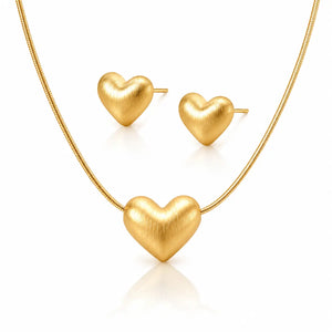 Gold heart-shaped necklace and earrings on a white background