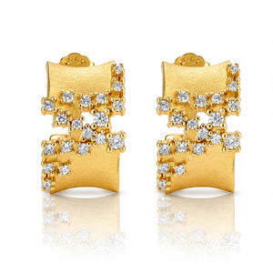 A pair of gold geometric stud earrings with clear gemstones, displayed on a clean white background with a soft reflection below.