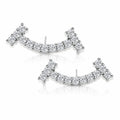 A pair of silver-toned crescent-shaped stud earrings set with clear pavé gemstones, displayed on a clean white background with a soft reflection.