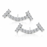 A pair of silver-toned crescent-shaped stud earrings set with clear pavé gemstones, displayed on a clean white background with a soft reflection.
