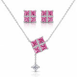 Silver-tone jewelry set featuring a necklace, matching stud earrings, and a small pendant charm. The necklace and earrings have square pink gemstone centers set with clear stones in a cross pattern, with the necklace chain extending to the edges of the frame.