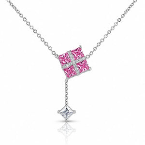 A silver-toned necklace featuring a Y-shaped chain with a square pendant filled with bright pink stones and a small diamond cross, with a dangling star-shaped clear gemstone at the bottom.