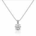 A silver solitaire necklace with a round-cut diamond pendant and a pavé diamond bail, displayed on a clean white background with a soft reflection below.