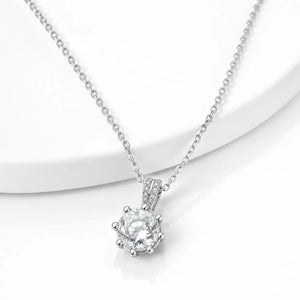 A silver-toned necklace with a delicate cable chain and a heart-shaped bezel-set clear gemstone pendant, displayed on a clean white background.
