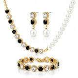 A gold-plated jewelry set featuring a pearl and black crystal necklace, matching drop earrings, and a bracelet, displayed on a clean white background.