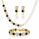 A gold-plated jewelry set featuring a pearl and black crystal necklace, matching drop earrings, and a bracelet, displayed on a clean white background.