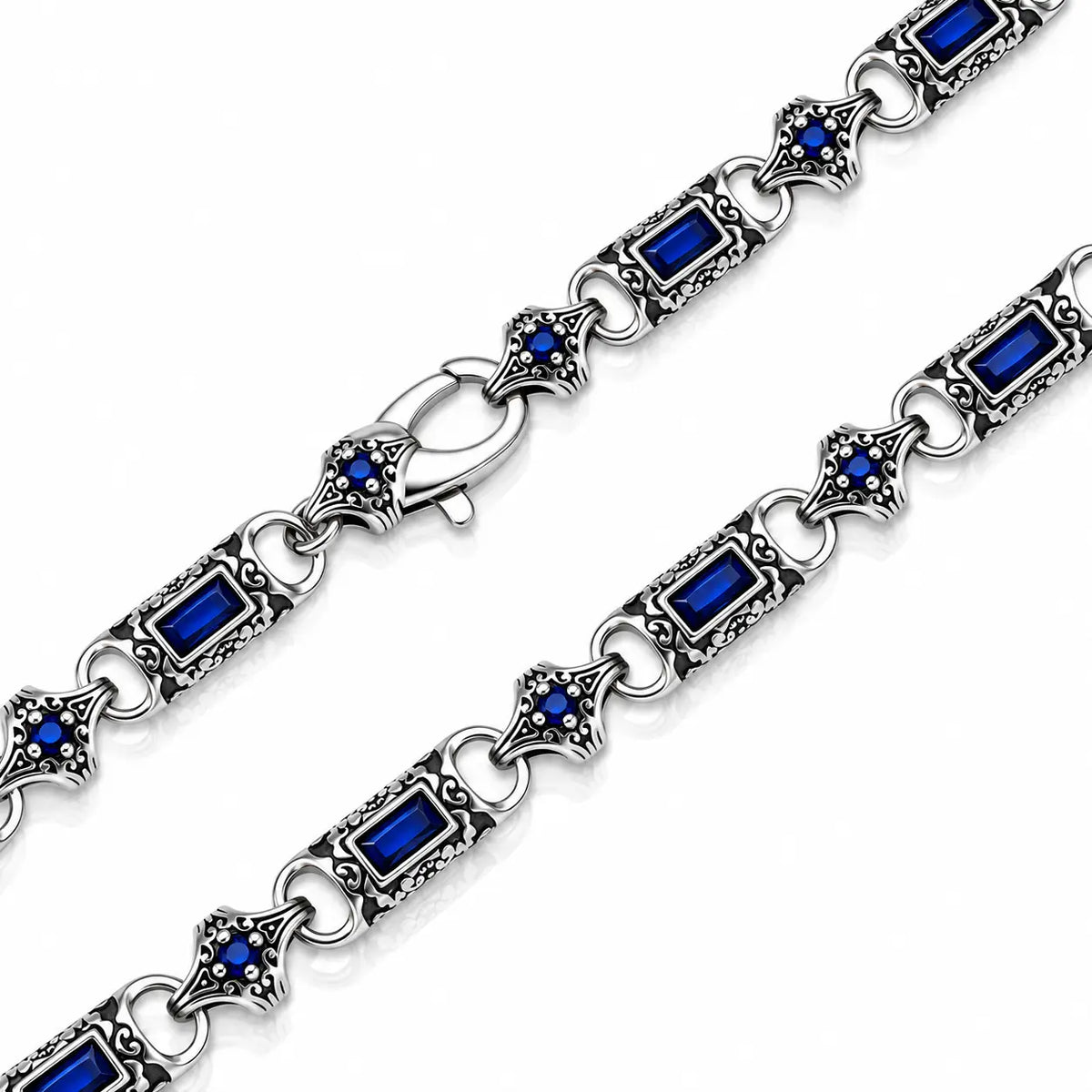 Silver-toned chain bracelet with rectangular blue gemstones and ornate filigree diamond-shaped links, shown on a white background.