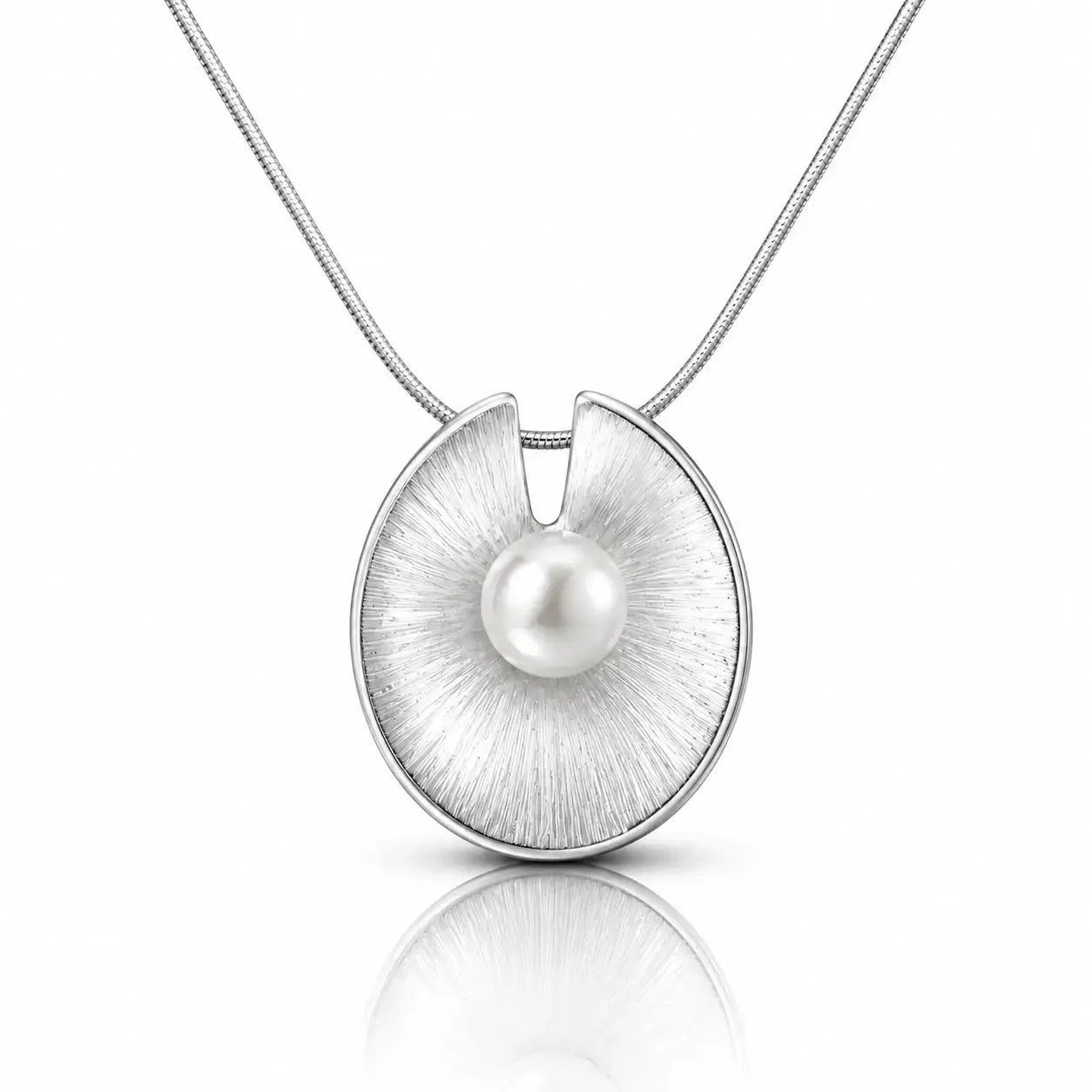 A silver pendant necklace featuring a brushed circular disc with a single white pearl at its center, suspended from a fine silver chain on a white background with a soft reflection below.