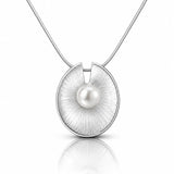 A silver pendant necklace featuring a brushed circular disc with a single white pearl at its center, suspended from a fine silver chain on a white background with a soft reflection below.