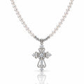 A silver cross pendant necklace with a strand of white pearls, featuring clear gemstones set into the cross and along the chain, shown on a white background with a soft reflection below.