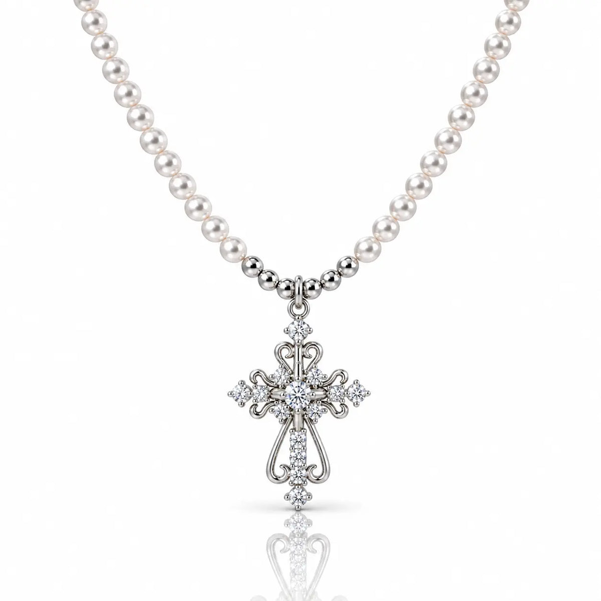 A silver cross pendant necklace with a strand of white pearls, featuring clear gemstones set into the cross and along the chain, shown on a white background with a soft reflection below.