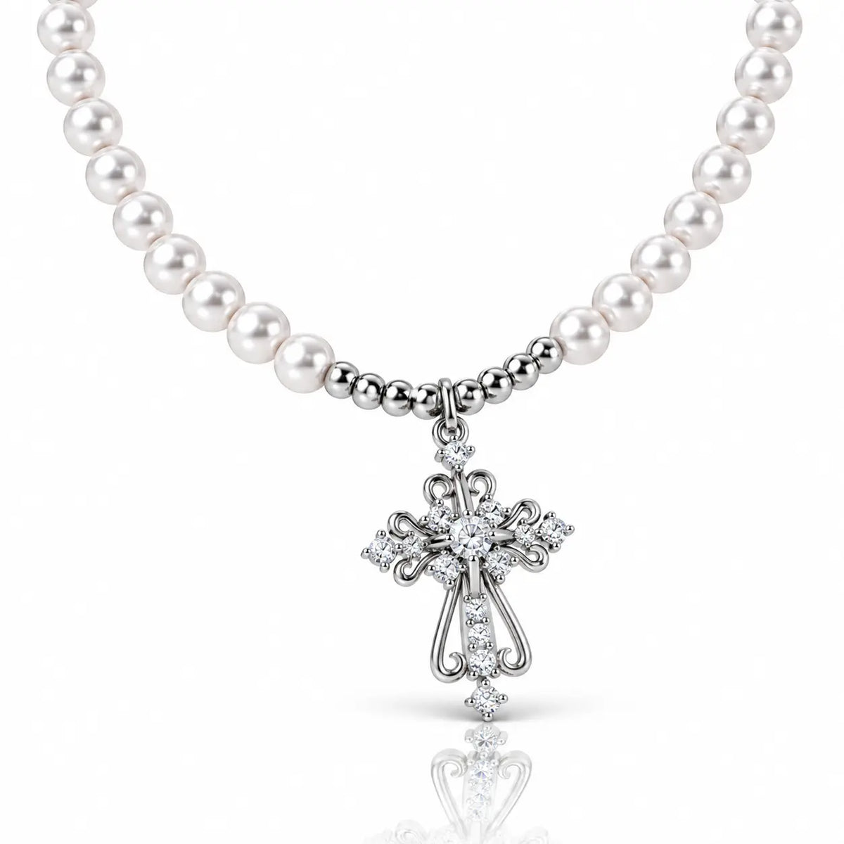 A white pearl necklace with a silver-toned cross pendant adorned with clear crystals, shown on a clean white background with a soft reflection below.