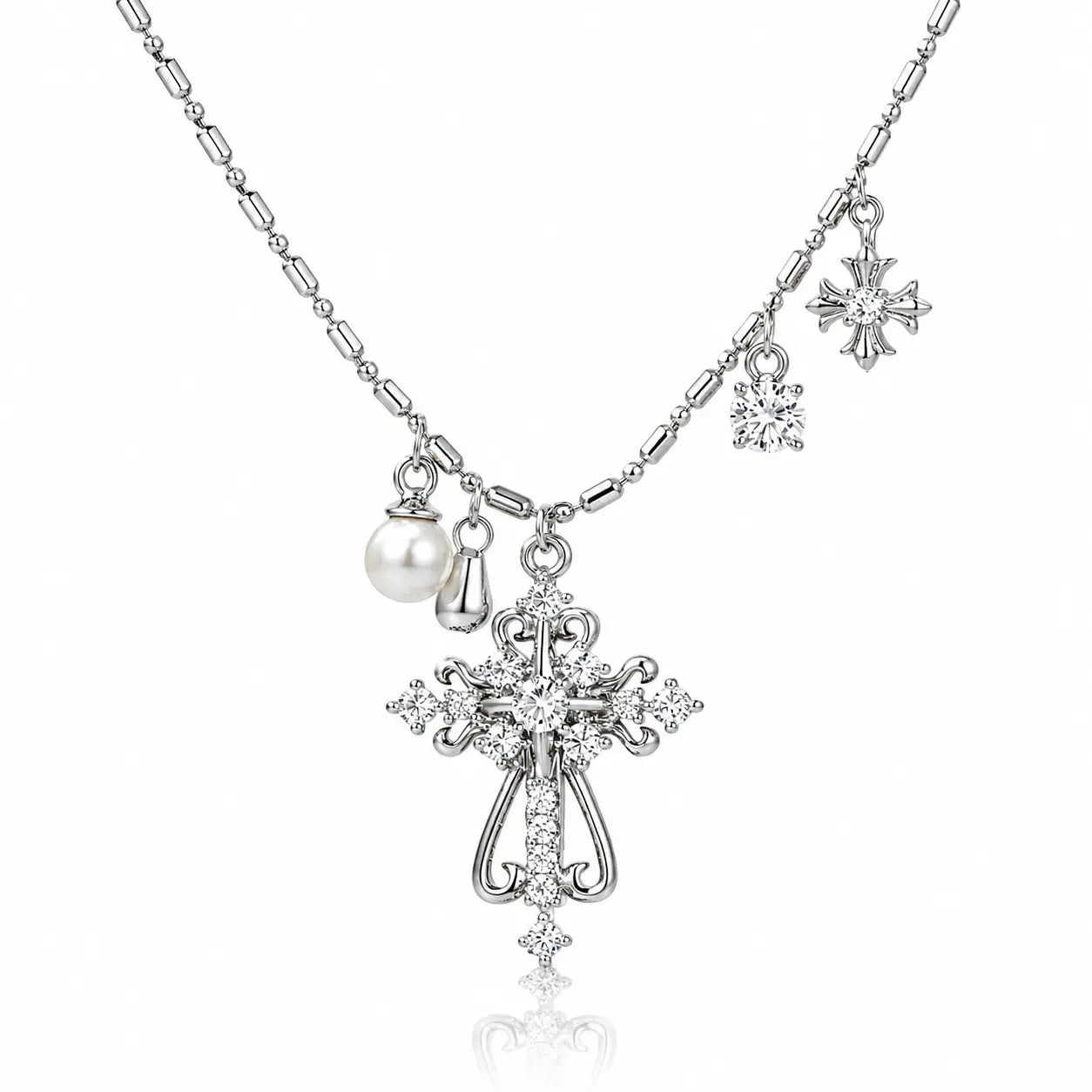 Silver-tone cross pendant necklace with clear rhinestones, a pearl charm, and snowflake charms on a white background.