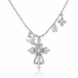 Silver-tone cross pendant necklace with clear rhinestones, a pearl charm, and snowflake charms on a white background.