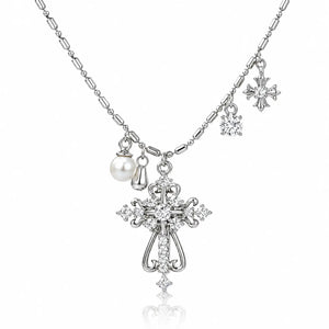 Silver-tone cross pendant necklace with clear rhinestones, a pearl charm, and snowflake charms on a white background.