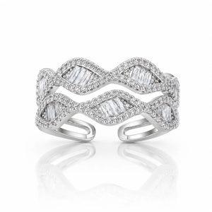 A silver-toned open cuff ring featuring a wavy, layered design paved with small clear stones and accented with larger baguette-cut clear stones, shown on a white background with a soft reflection.