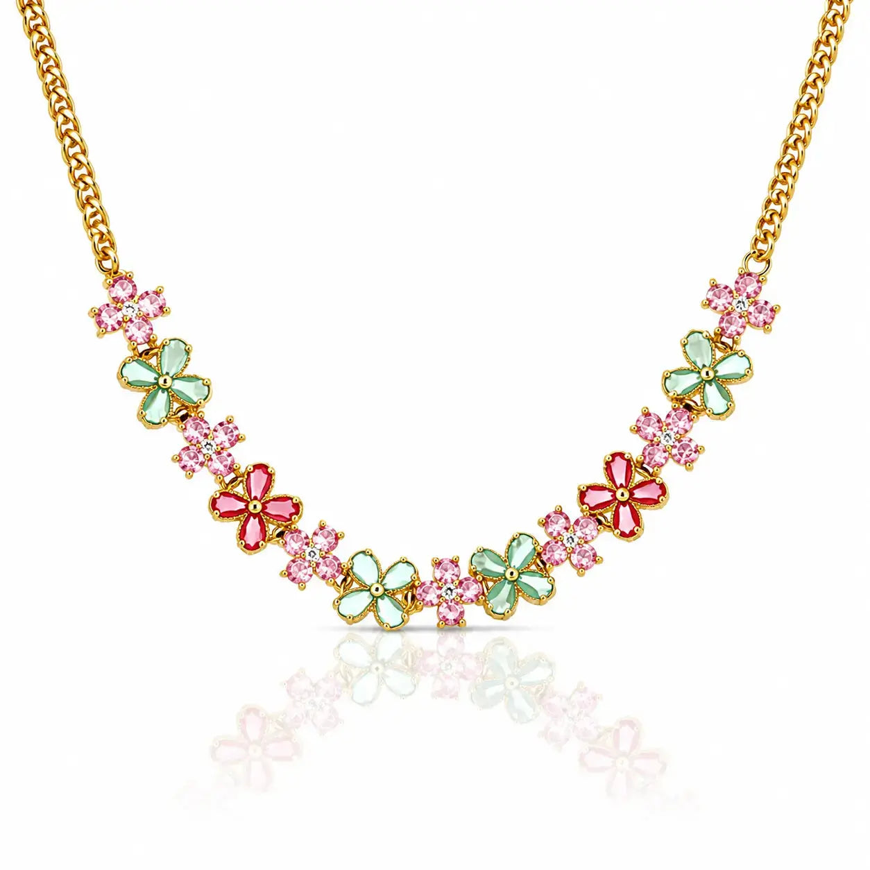 A gold chain necklace featuring a series of colorful flower charms in pink and mint green, displayed on a clean white background with a soft reflection below.