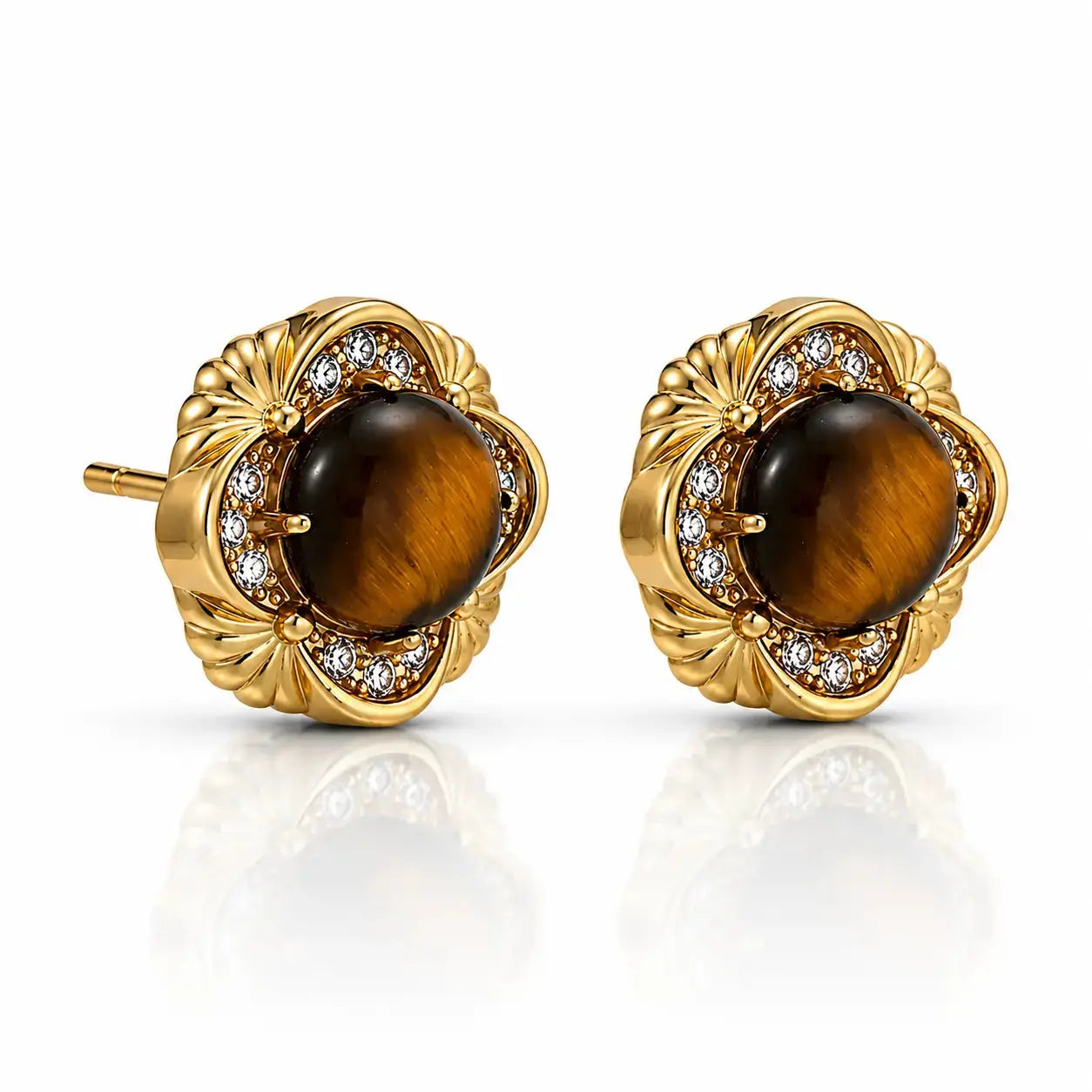 A pair of gold stud earrings featuring round brown tiger's eye centers, surrounded by a halo of small clear stones and a scalloped gold setting, shown on a white background with a soft reflection.