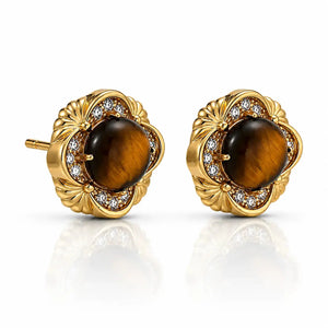 A pair of gold stud earrings featuring round brown tiger's eye centers, surrounded by a halo of small clear stones and a scalloped gold setting, shown on a white background with a soft reflection.