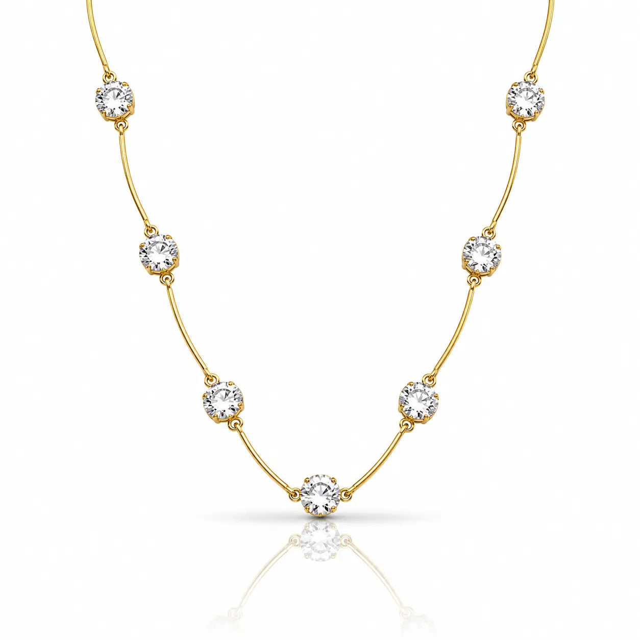 A delicate yellow gold necklace featuring seven round-cut clear gemstones spaced along the chain, displayed on a clean white background with a soft reflection below.