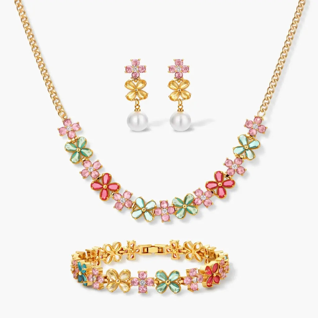 Floral jewelry set with gold necklace, bracelet, and earrings featuring colorful enamel flowers and pink gemstones