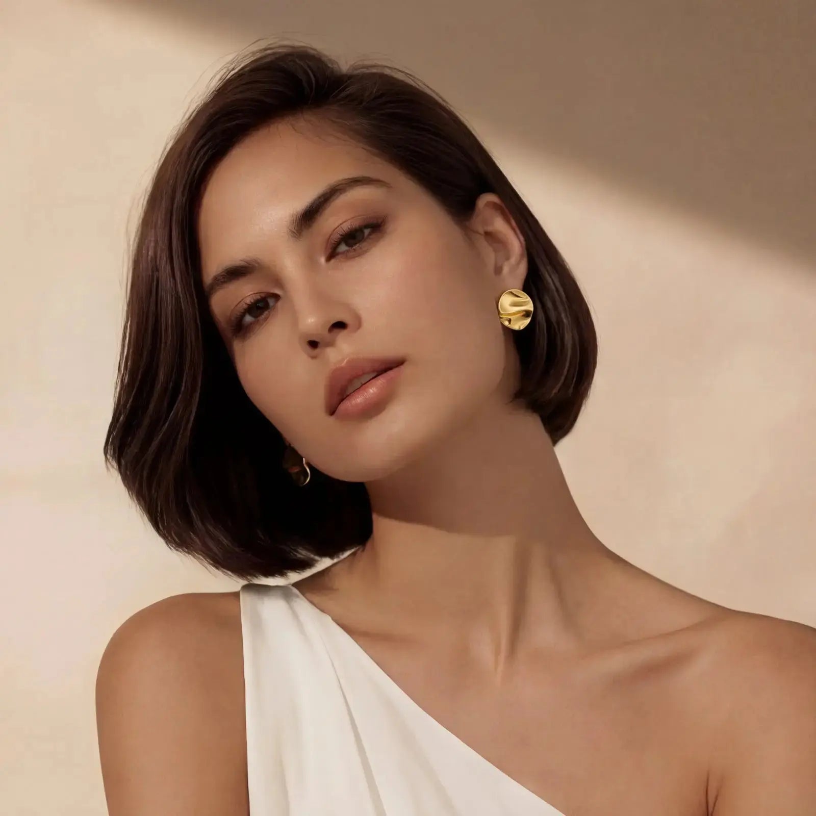 Woman wearing elegant 18K gold plated sterling silver stud earrings, minimalist style