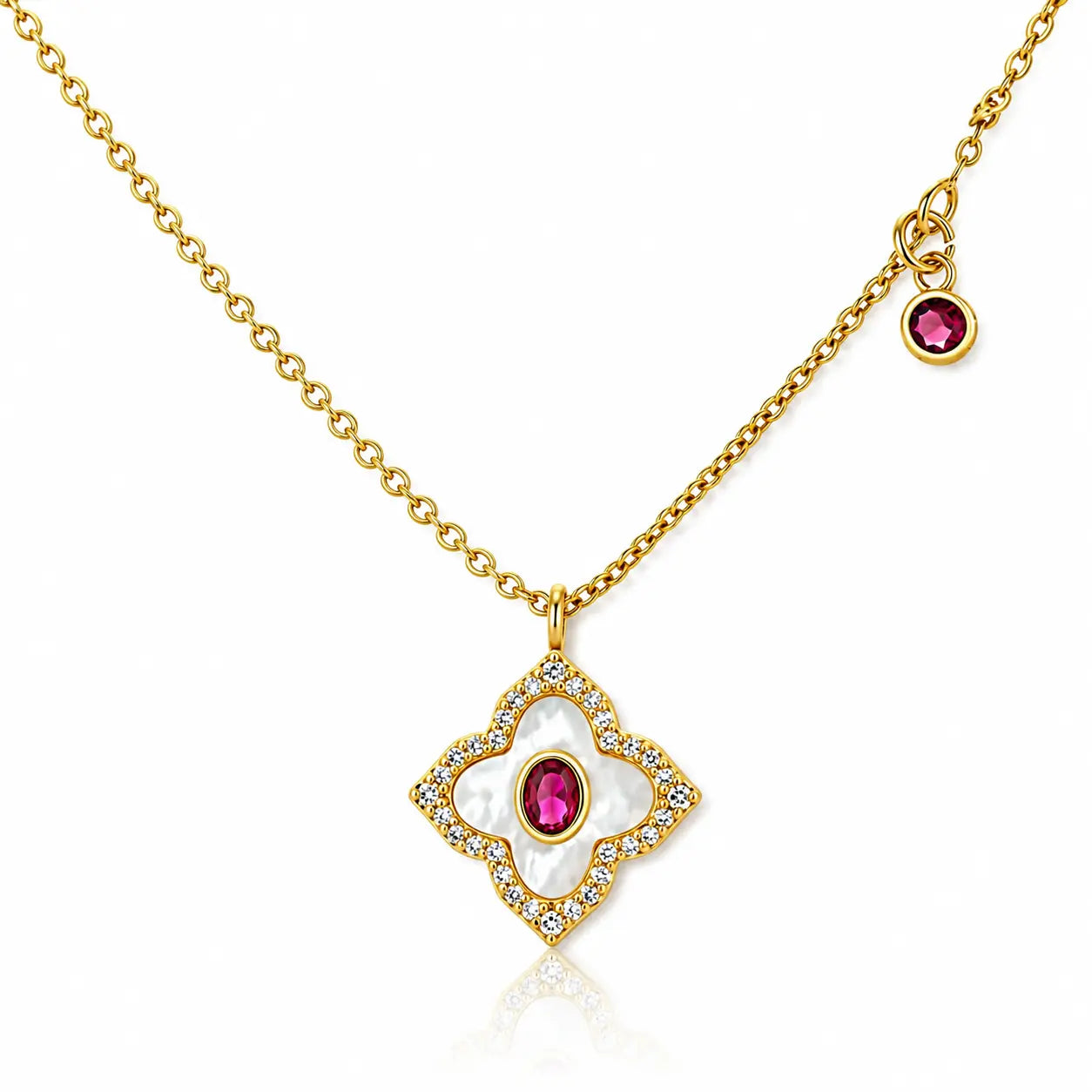 A gold chain necklace featuring a diamond-shaped pendant with a white mother-of-pearl floral center, small clear stones, and a pink gemstone, plus a small dangling charm with a pink gemstone, on a white background.