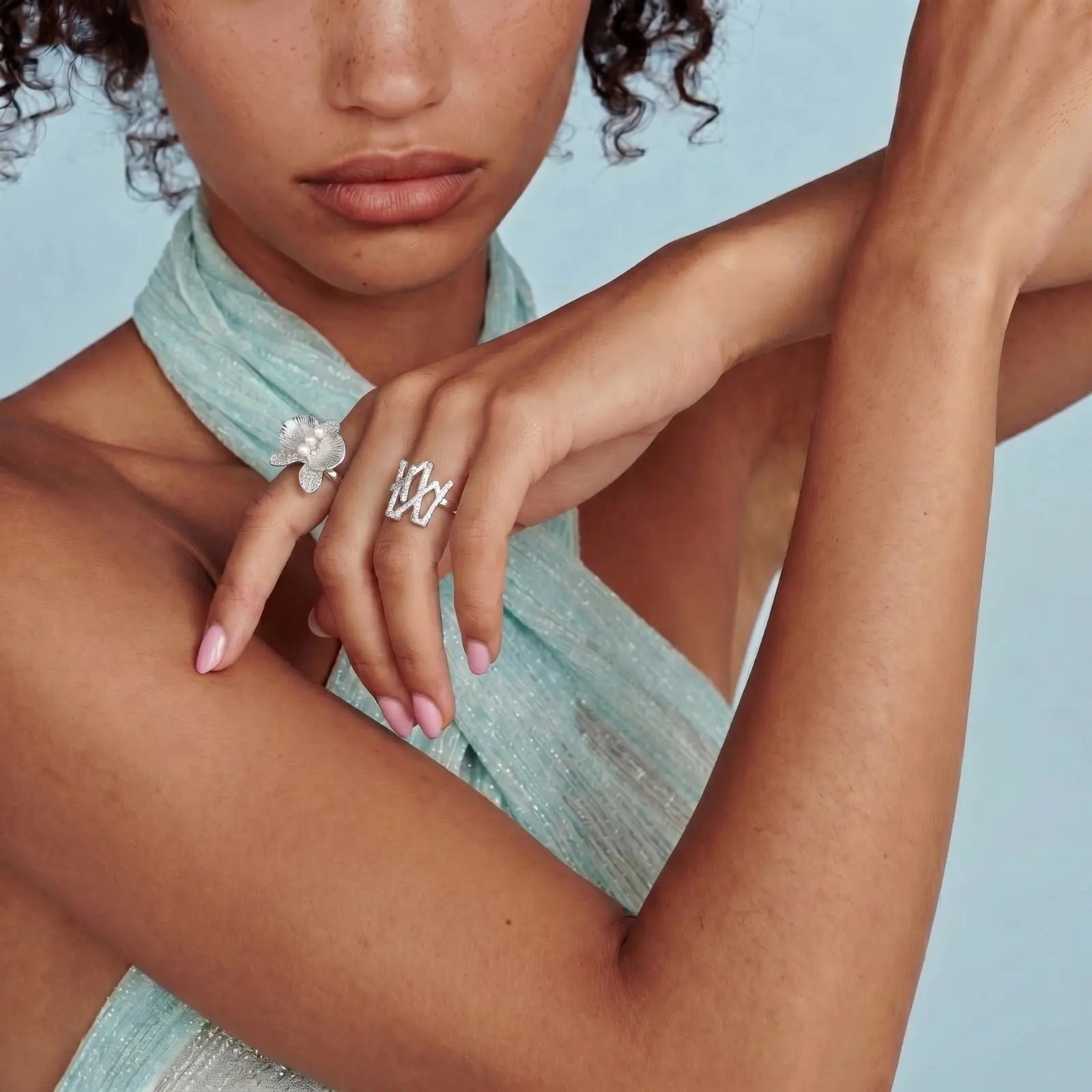Woman wearing a silver ring with a flower design on a light blue background