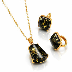 Gold necklace with black and gold pendant on a white background