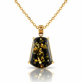 A gold pendant necklace featuring a faceted shield-shaped black stone with shimmering gold inclusions, suspended from a delicate gold chain on a white background with a soft reflection.