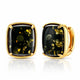 A pair of gold-toned cushion-cut stud earrings with black onyx-like centers containing metallic gold flecks, shown on a clean white background with a soft reflection.
