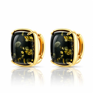 A pair of gold-toned stud earrings with cushion-cut black onyx-like stones containing golden inclusions, shown on a white background with a soft reflection below.