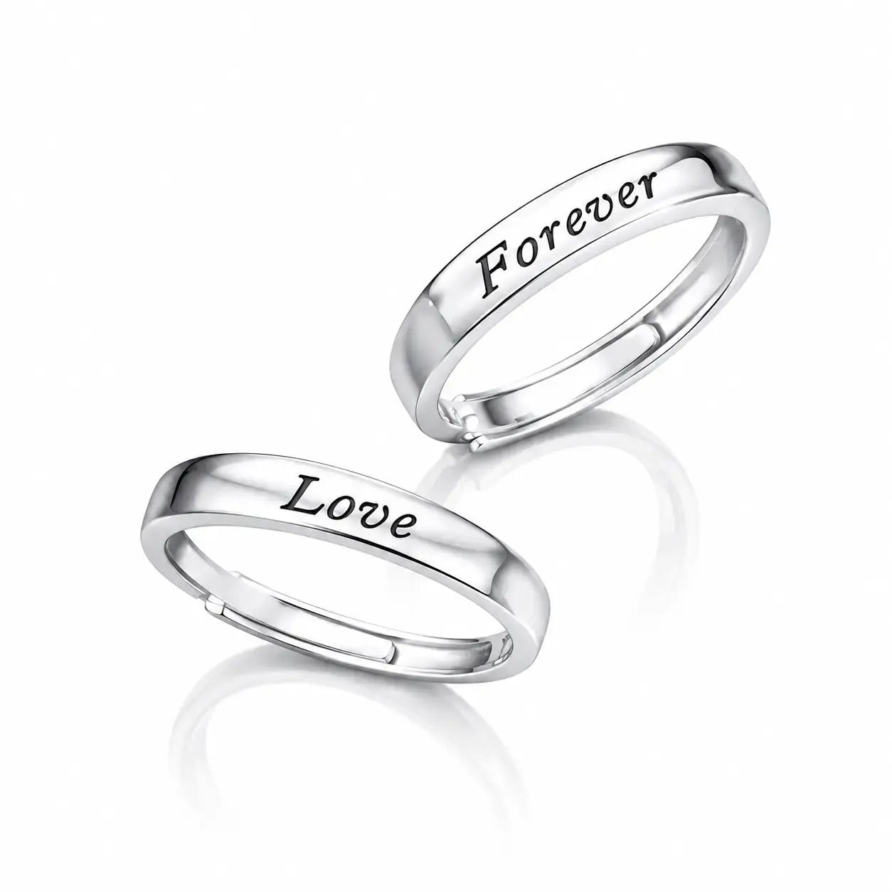 Two polished silver rings on a white reflective background, one engraved with the word 'Love' and the other with 'Forever'.