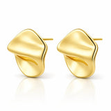 A pair of gold abstract stud earrings with a smooth, organic wavy design, displayed on a clean white background with a soft reflection below.