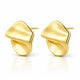 A pair of gold abstract stud earrings with a smooth, organic wavy design, displayed on a clean white background with a soft reflection below.