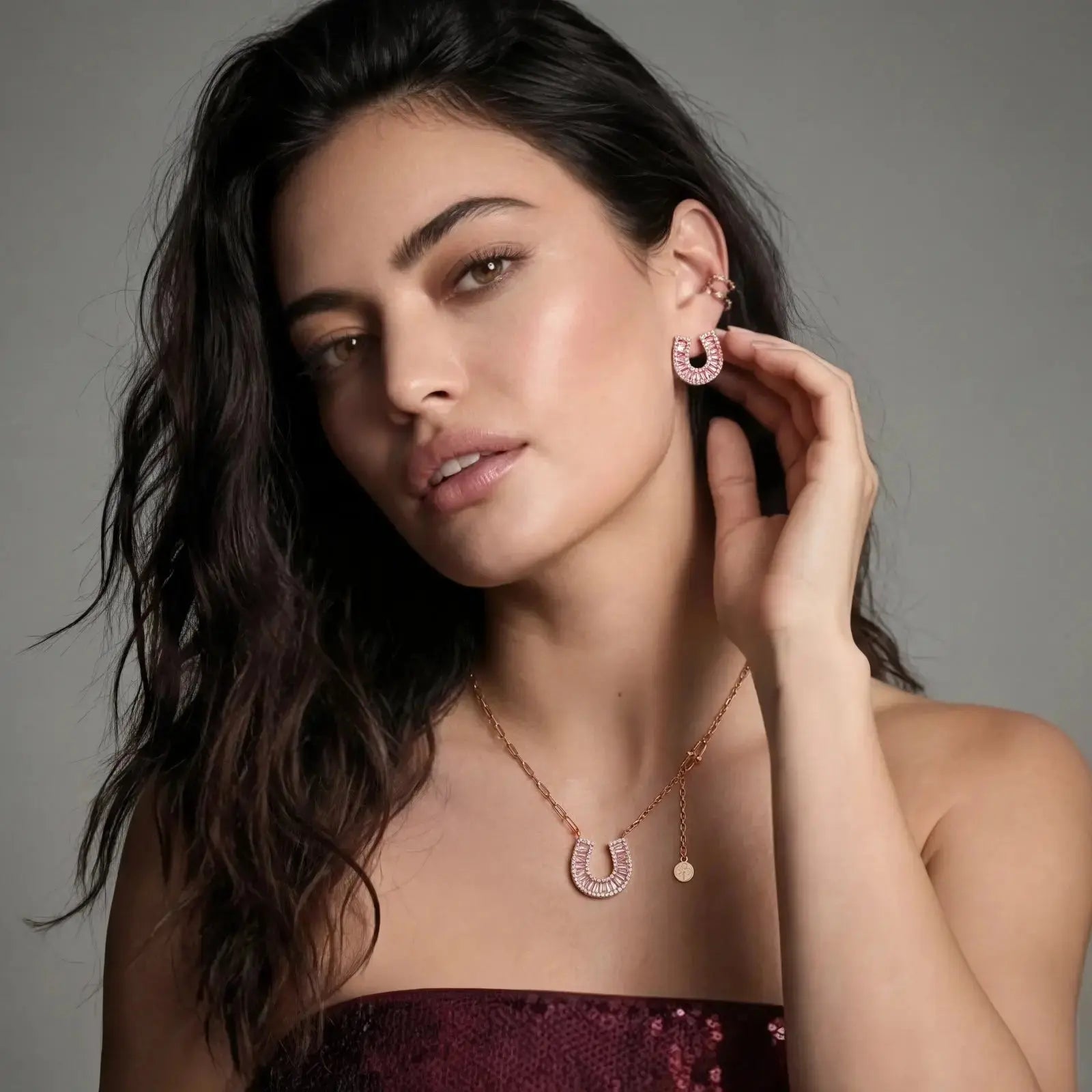 Woman wearing sparkling horseshoe pendant necklace and matching horseshoe earrings