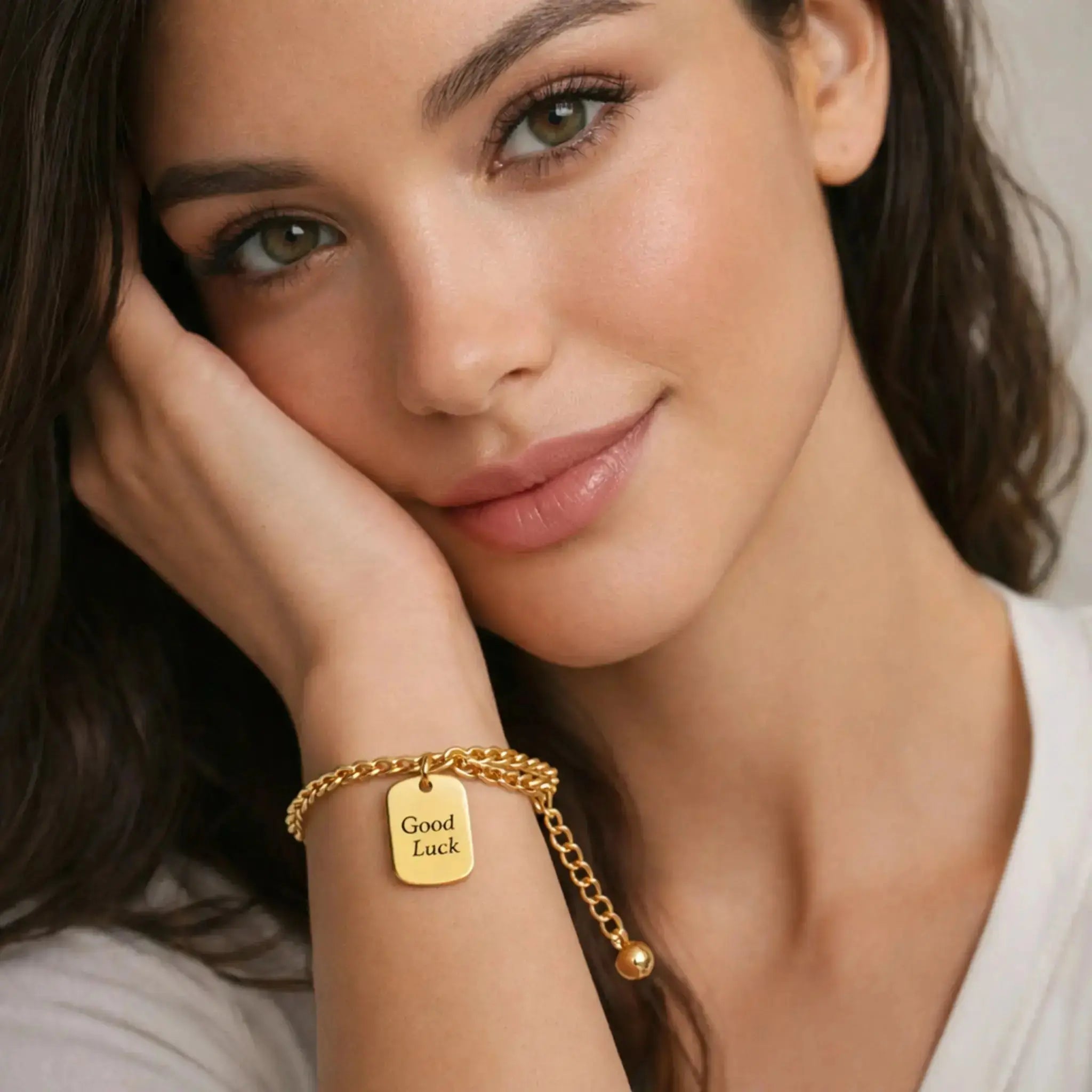 Woman wearing an 18K gold bracelet with a 'Good Luck' tag charm