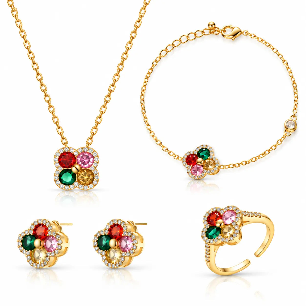 A gold jewelry set featuring a necklace, bracelet, earrings, and ring, each with a four-petal flower design set with red, green, pink, and yellow gemstones and small clear stones.