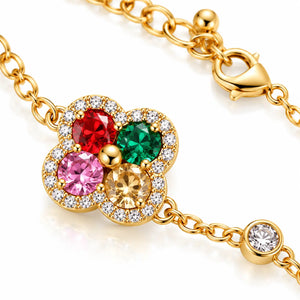 Gold-tone floral charm bracelet featuring four round gemstones in red, green, pink, and yellow, surrounded by clear crystal accents, on a white background.