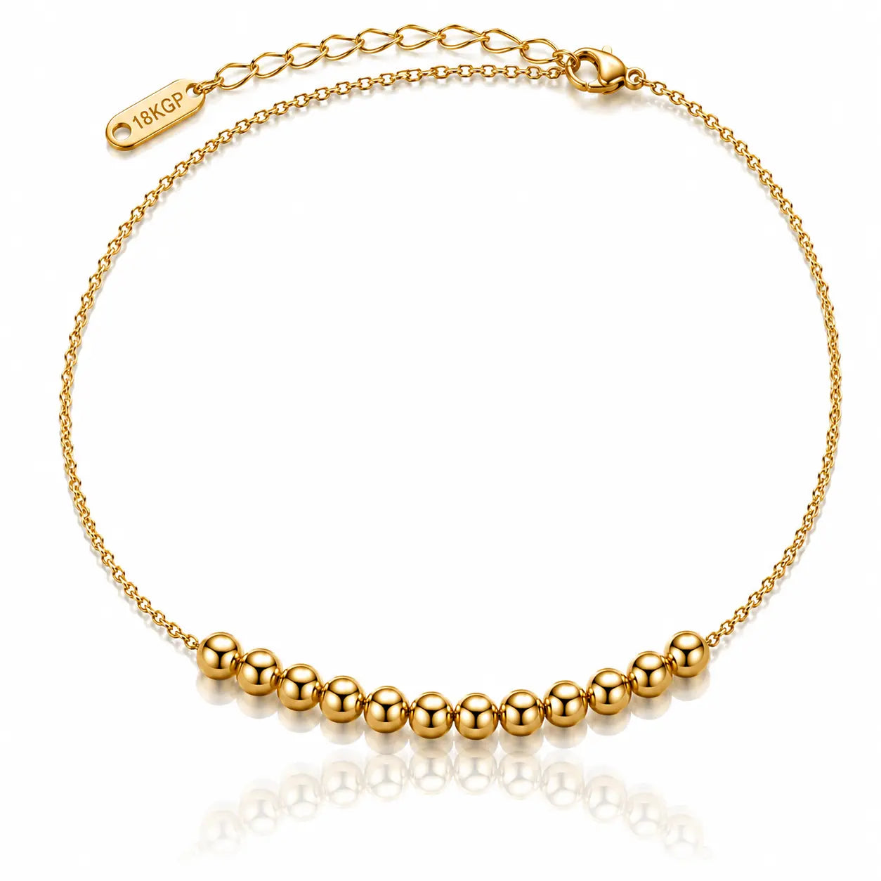 A delicate gold chain anklet featuring a row of polished gold beads along the bottom curve, with an adjustable lobster clasp and extender chain marked '18KGP'.