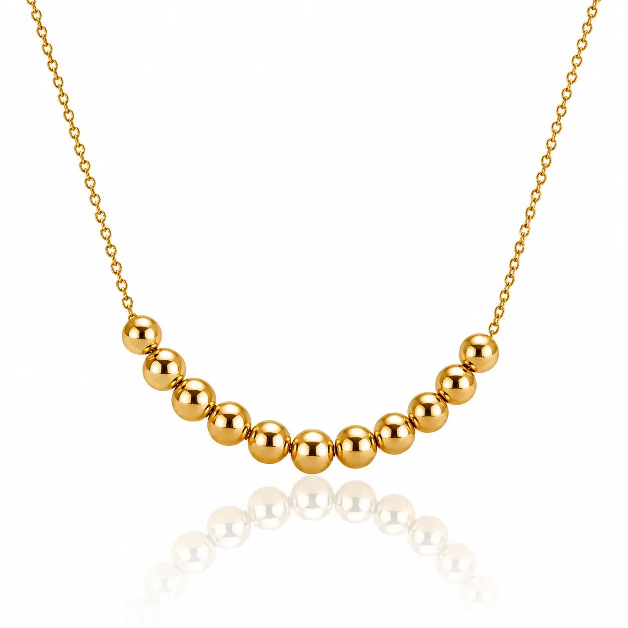 A gold beaded necklace featuring a curved row of polished spherical beads on a delicate gold chain, displayed against a clean white background with a soft reflection below.