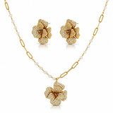 Gold-tone floral jewelry set with a pendant necklace, matching stud earrings, and a chain featuring small white pearls, shown on a clean white background.