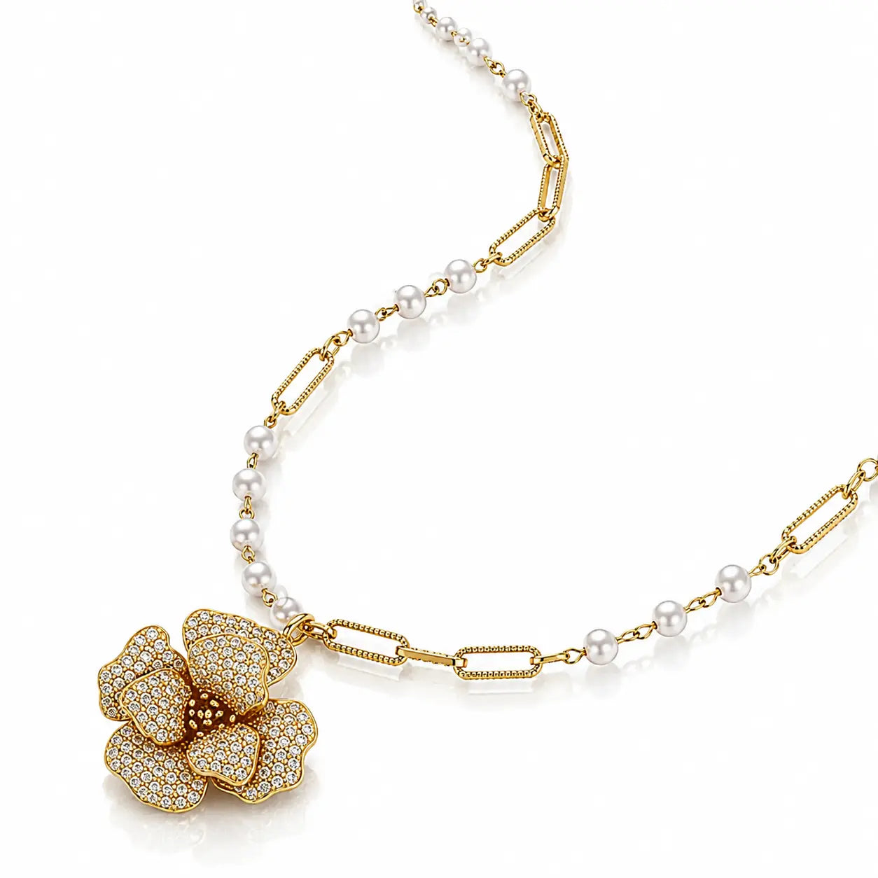 A luxury gold and pearl necklace featuring a large flower-shaped pendant paved with small clear stones, accented by a chain of white pearls and gold paperclip links, on a white background.